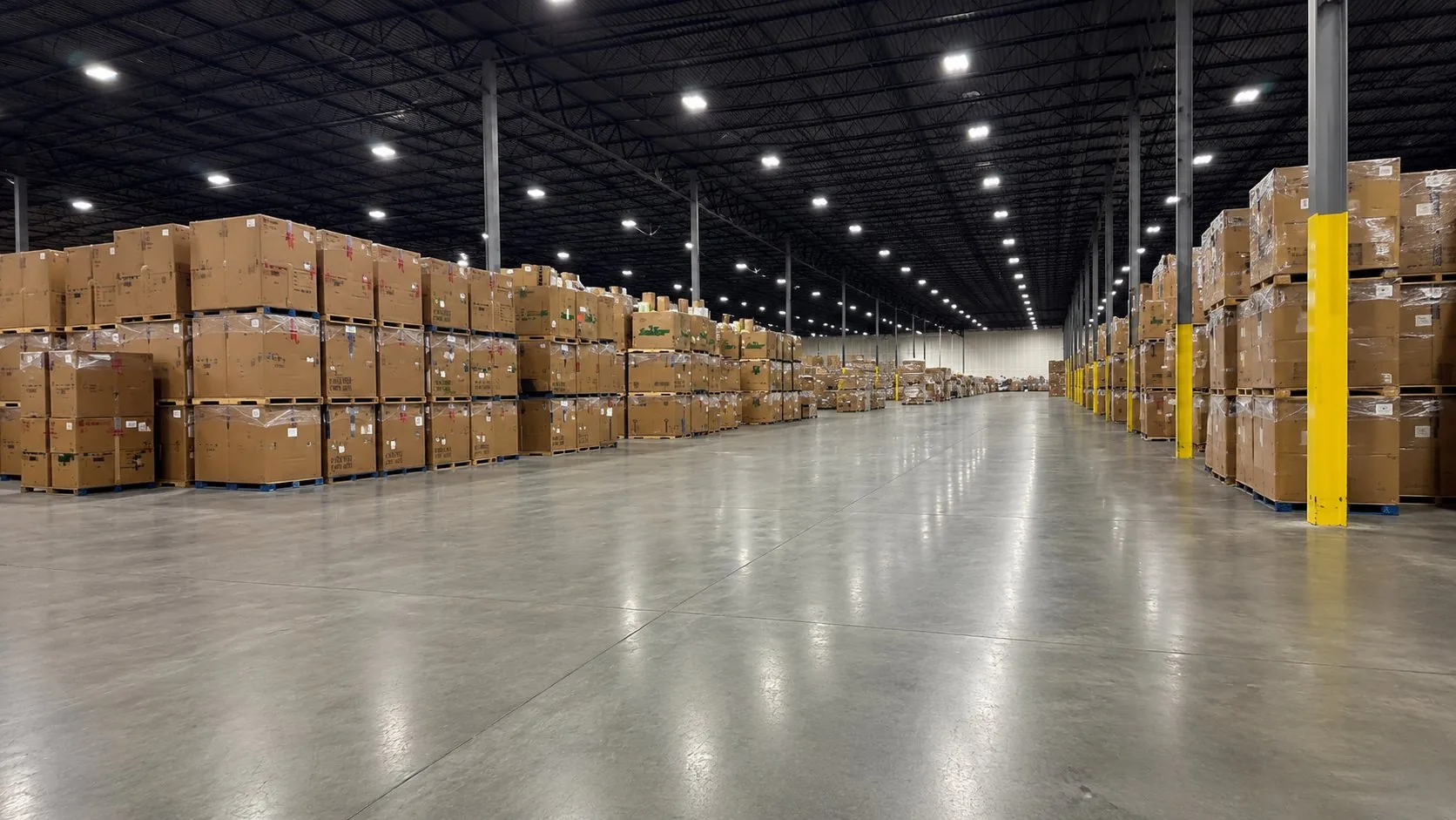 Warehouse operations team reviewing AI-powered logistics platform on tablet beside pallet racking, ORVX AI helps Australian distribution centres automate pick-and-pack, workforce scheduling, and real-time inventory tracking